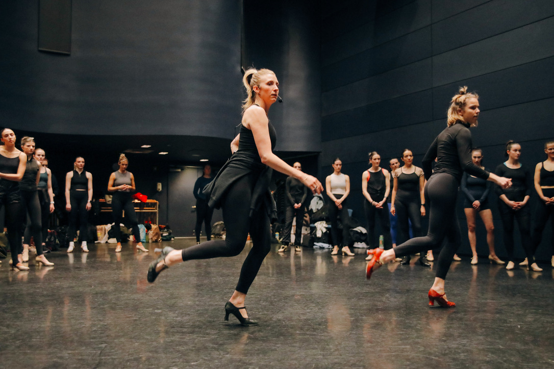 Sarah Hoge demonstrating across the floor as dancers watch